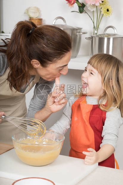 三岁的孩子和母亲在吸了手指来尝奶油之后笑着高清图片下载-正版图片507354030-摄图网