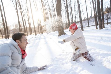 在雪地上玩耍的快乐父子高清摄影大图-千库网