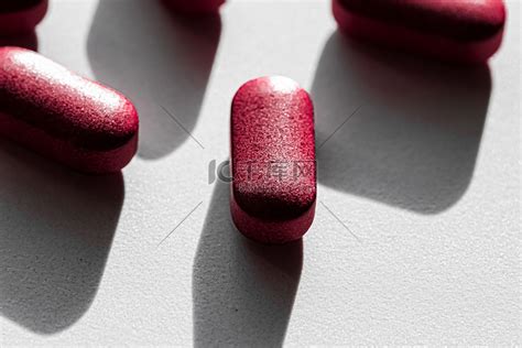 一颗红色药丸隔离在白色高清摄影大图-千库网