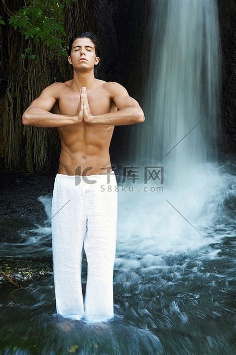 男子站在瀑布边的河中冥想，正面观，全长高清摄影大图-千库网