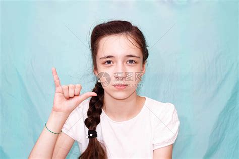 一个留着长辫子的女孩用手聋哑人的手语展示字母Y中等计划高清图片下载-正版图片504073896-摄图网