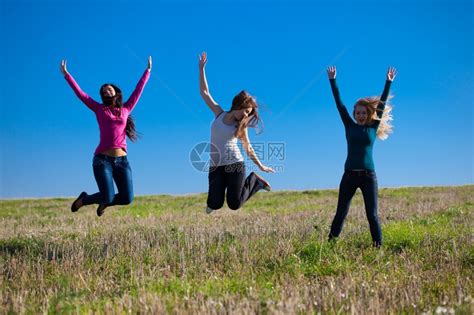 三名美丽的年轻姑娘跳上田地对着天空高清图片下载-正版图片306871747-摄图网