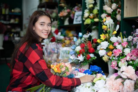 年轻漂亮的花店女店员在一家花店工作照片摄影图片_ID:352230081-Veer图库