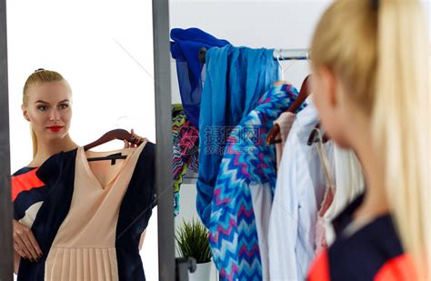 美貌金发美女在镜子前服装店试穿新衣服的反射高清图片下载-正版图片504878182-摄图网