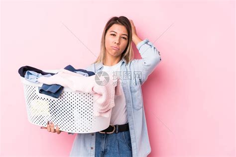 年轻caucasian女人拿起一件脏衣服高清图片下载-正版图片504056510-摄图网