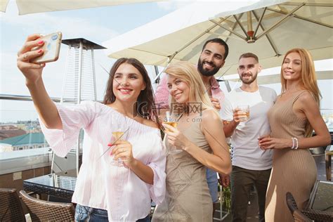 一群朋友在屋顶派对上喝酒高清摄影大图-千库网