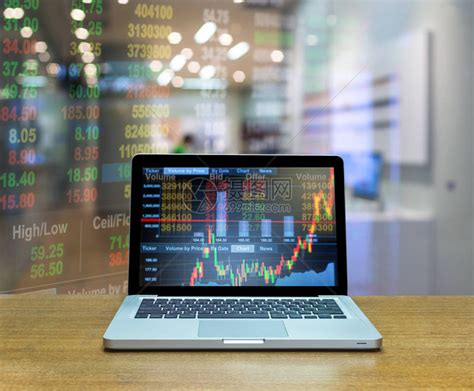 木桌上笔记本电脑屏幕上的证券交易所市场交易图高清图片下载-正版图片503496995-摄图网