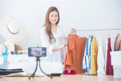 美丽的亚洲女博主在镜头前展示衣服高清图片下载-正版图片503503589-摄图网