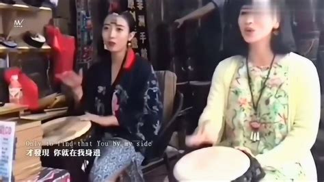 丽江美女小倩边打手鼓边唱《一瞬间》吸引了不少人驻足观看_腾讯视频