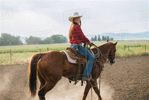 Woman horseback riding - Stock Photo - Dissolve