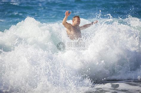 年轻人在暴海中洗澡高浪冲过水高清图片下载-正版图片503582429-摄图网