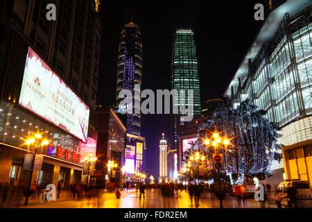 China, Chongqing, Jiefangbei or Victory Monument, floodlit clock-tower surrounded by a busy ...