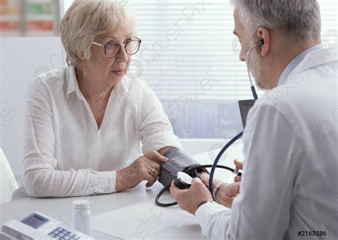 Médico que mide la presión arterial de un - foto de stock 2163586 ...