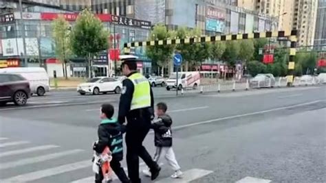 交警双手各牵一名无人看管的孩子，安全护送过马路_@所有人_澎湃新闻-The Paper