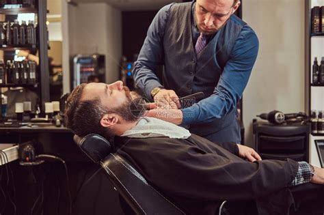 理发店男顾客正在接受理发图片-男性理发师在为男子理发素材-高清图片-摄影照片-寻图免费打包下载