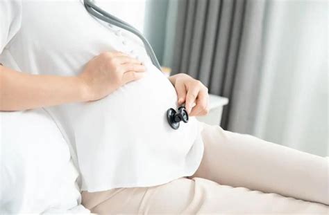 怀孕和人的概念-快乐怀孕的亚洲妇女与胎儿超声图像和笔记本或日记在家里的床上。高清摄影大图-千库网