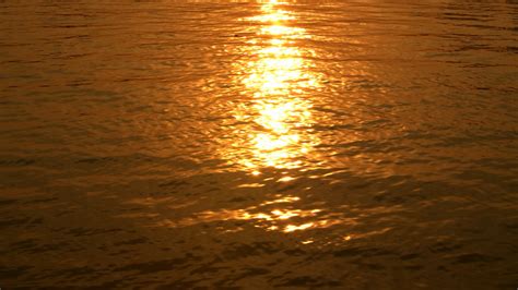 夕阳下波光粼粼的水面|波光粼粼,橙色天空,风景图片,摄影图片,水波,水面,夕阳,云朵,自然风光