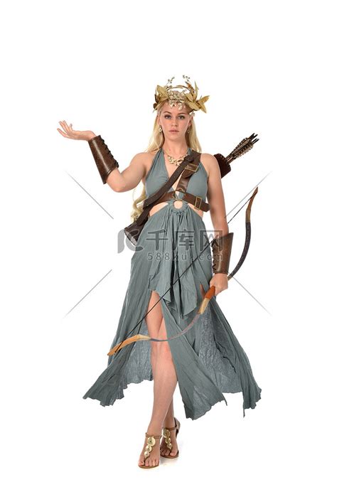 全长肖像漂亮的金发女郎穿着梦幻长袍, 并持有弓和箭。在白色背景上站立姿势.高清摄影大图-千库网