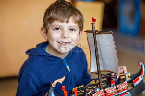 金发碧眼的学龄前儿童男孩在室内玩具船前面缺牙的孩子放学后在托儿所玩得开心快乐的男孩建高清图片下载-正版图片502509938-摄图网