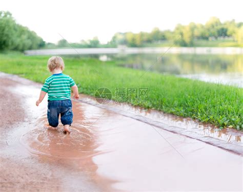 孩子在雨后的水坑上行走高清图片下载-正版图片504761329-摄图网
