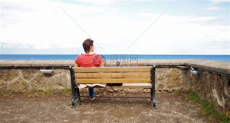 海滩一种孤单的女人坐在海边长椅上看着大海快乐的高清图片下载-正版图片307768874-摄图网