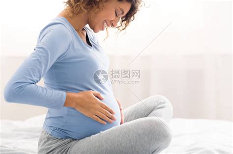快乐的孕妇抚摸肚子享受未出生婴儿被推高清图片下载-正版图片506297215-摄图网