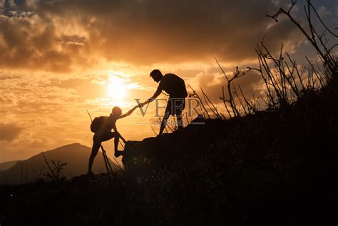 日出时，人们互相帮助爬山。照片摄影图片_ID:307529017-Veer图库