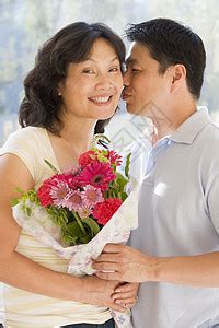 丈夫和妻子怀着礼物的亲吻和微笑高清图片下载-正版图片320162529-摄图网