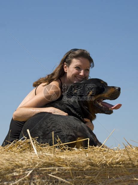 微笑的年轻女人和她的大黑狗高清图片下载-正版图片506961999-摄图网