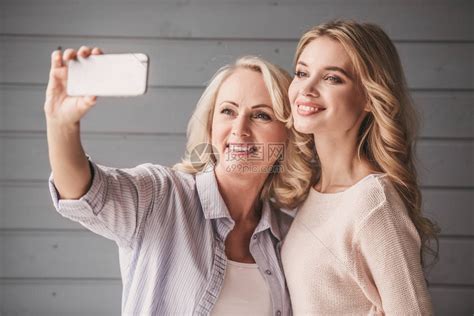 美丽的老妈和成年女儿正用智能手机拍自高清图片下载-正版图片503382221-摄图网