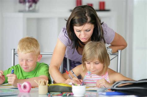 母亲帮助孩子们做家庭作业图片-帮助孩子们做家庭作业的年轻母亲素材-高清图片-摄影照片-寻图免费打包下载