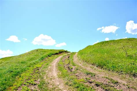 Premium Photo | Dirty road going up the hill with blue sky copy space