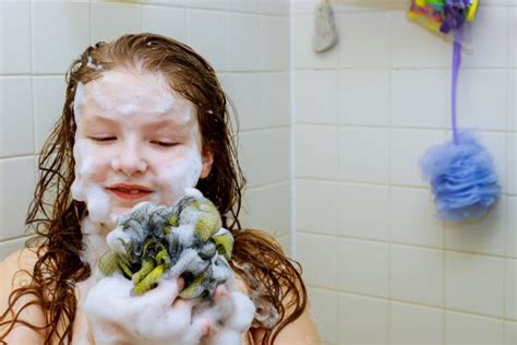 年轻女子在淋浴时用泡沫去屑洗发水洗头。照片摄影图片_ID:428018268-Veer图库