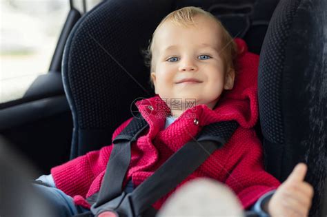 可爱的白种人蹒跚学步男孩坐在汽车的儿童安全座椅上高清图片下载-正版图片503675657-摄图网