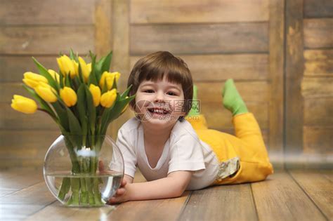 一个拿着一束黄色郁金香的小孩一个男孩拿着花瓶里的鲜花礼物给女假期女孩的礼物高清图片下载-正版图片506056209-摄图网