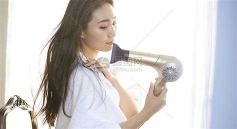 女人用吹风机吹头发高清图片下载-正版图片502155710-摄图网