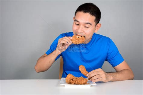 年轻人在桌子上吃炸鸡高清图片下载-正版图片502787038-摄图网