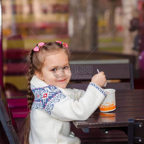小女孩吃冰淇淋小女孩在街上的咖啡馆里高清图片下载-正版图片507403391-摄图网