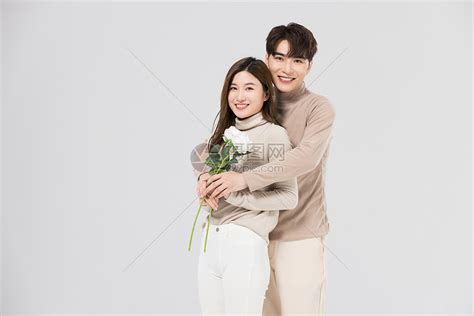 韩系情侣亲密拥抱手拿玫瑰花高清图片下载-正版图片502357477-摄图网