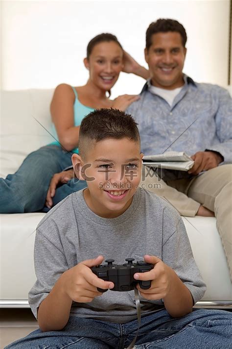 父母看儿子玩电子游戏高清摄影大图-千库网