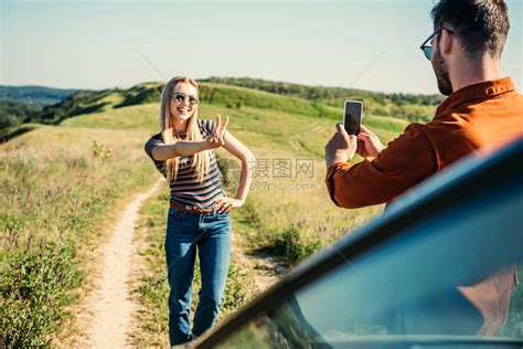男人拍照的女友在农村草地上的汽车附高清图片下载-正版图片503589644-摄图网