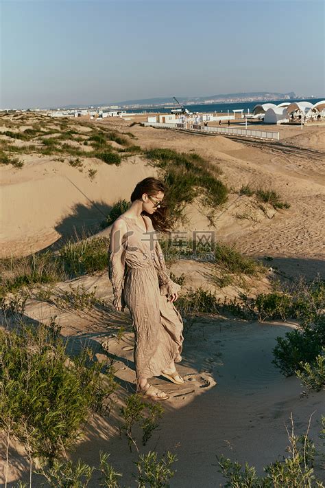 一个穿着长裙的苗条女人独自沿着荒凉的海滩散步高清摄影大图-千库网