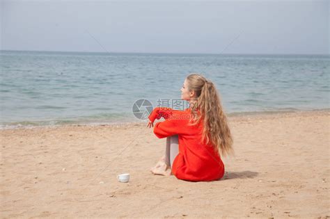 一个女人坐在荒凉的沙滩上高清图片下载-正版图片505705687-摄图网
