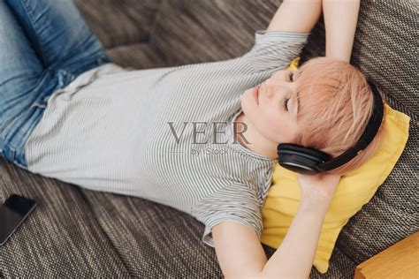 安详的年轻女子躺着听音乐照片摄影图片_ID:327452279-Veer图库