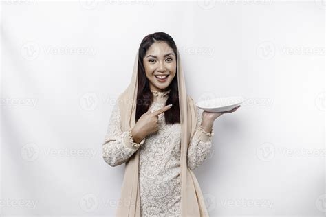 An Asian Muslim woman is fasting and hungry and holding utensils ...