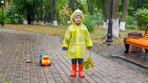 雨天在公园穿雨衣玩耍的男孩高清图片下载-正版图片306421885-摄图网