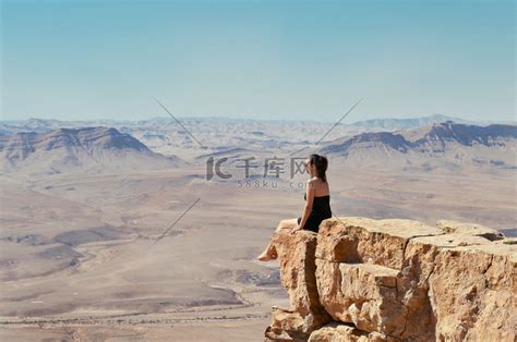 女孩看着沙漠景观的悬崖上高清摄影大图-千库网