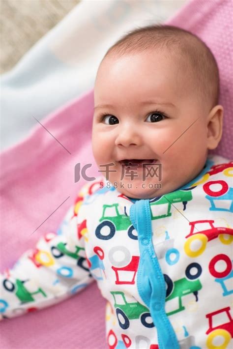 在家玩第一场游戏时，快乐美丽的新生男婴躺在彩色毯子上的俯视图高清摄影大图-千库网