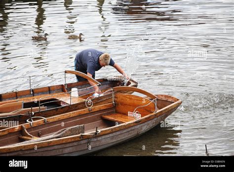 Young man bailing water out of rowing boat, Derwent water, Keswick ...