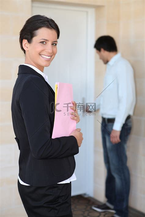 女房地产经纪人在门口与年轻客户微笑高清摄影大图-千库网